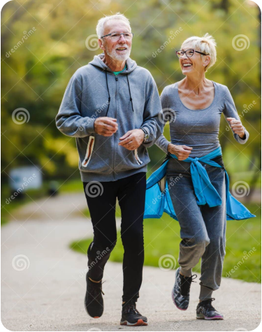 Photo of a senior woman sitting on a bench next to a walking trail in a park on a sunny day. She is holding her knee with a pained expression on her face.