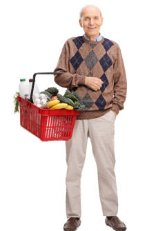 A senior man is standing on a mat doing a yoga pose with his hands over his head and his back straight.