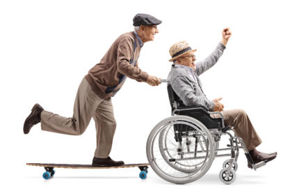 A senior man on a skateboard is pushing another senior man in a wheelchair